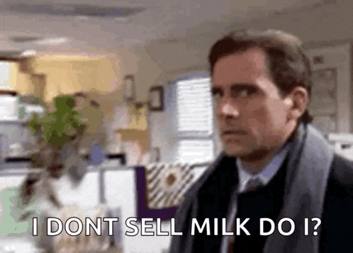 a man in a suit and tie is standing in an office and saying `` i dont sell milk do i '' .