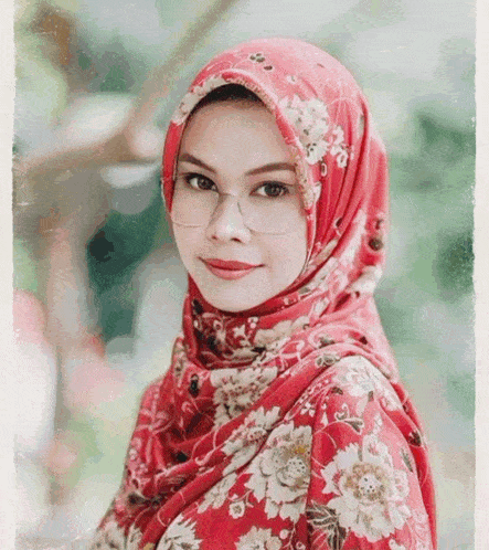 a woman wearing glasses and a red floral hijab