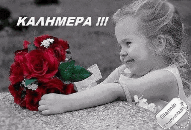 a little girl is smiling while holding a bouquet of red roses .