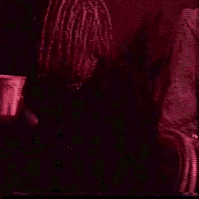 a person with dreadlocks is holding a cup that says mcdonalds on it