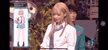 a girl with blonde hair and a blue tie is standing next to a boy in a suit .