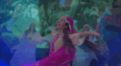 a woman in a yellow and pink dress is dancing with other women