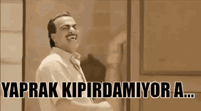 a man in a white shirt and tie is laughing with the words `` vaprak kipirdamiyor a ... '' .