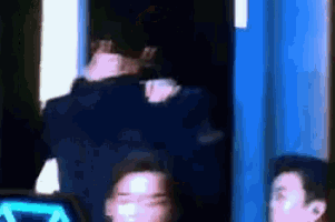 a group of people are standing in front of a blue wall in a room .