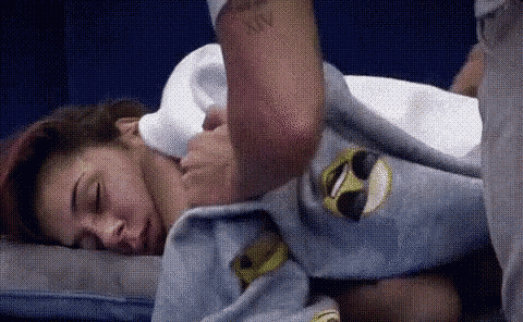 a man is putting a blanket over a woman 's shoulder .