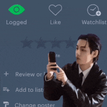 a man in a suit is holding a cell phone in front of a screen that says liked and watchlist
