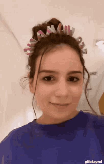 a woman wearing a blue shirt and a headband that says " gifsdayrol "