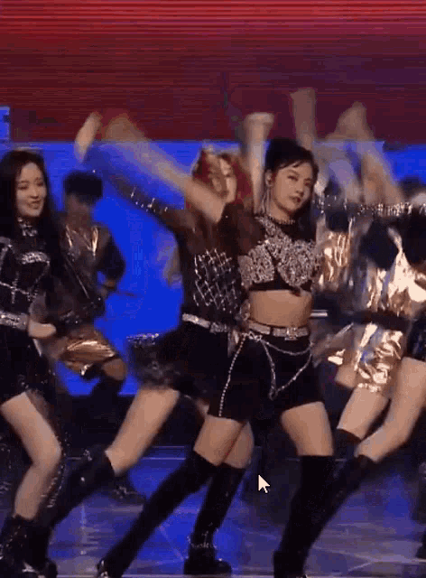 a group of women are dancing on a stage with a arrow pointing to the right