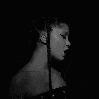 a black and white photo of a woman with braids .