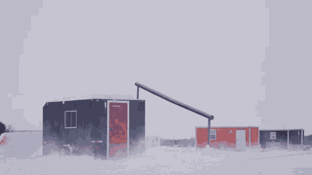 a snowboarder is doing a trick on top of a trailer that says ' ice fishing ' on it