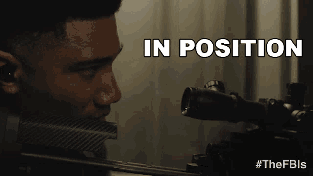 a man looking through a scope with the words in position behind him