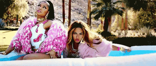 a couple of women are sitting next to each other in an inflatable pool .