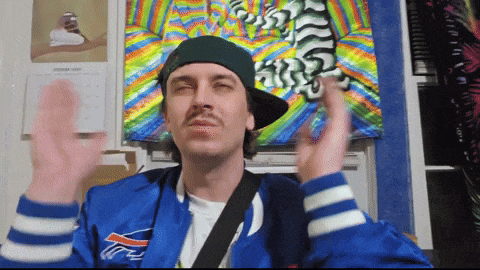 a man wearing a buffalo bills jacket is waving