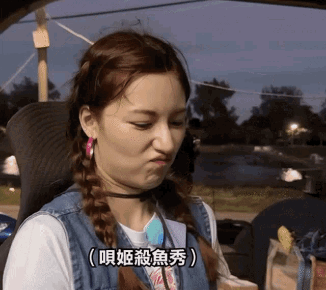a woman making a face with chinese writing on the bottom right