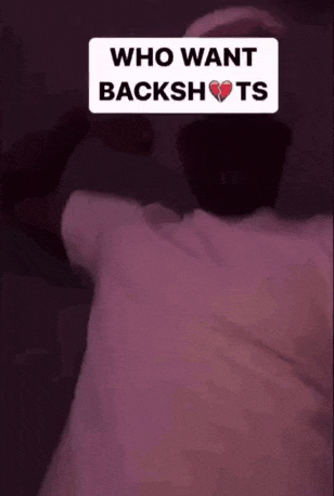 a man is standing in a dark room with his arms outstretched .