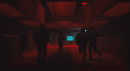 a blurred image of people standing in a dark room with the number 1 visible