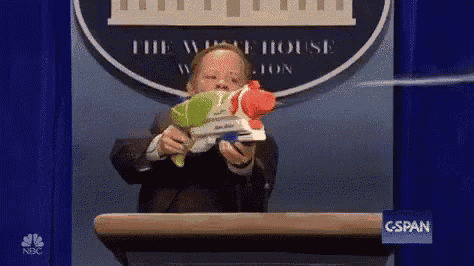 a man is holding a water gun in front of a podium .