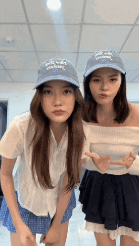 two girls wearing hats that say " almost almost " are posing for a photo