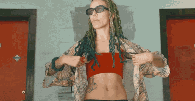 a woman with green dreadlocks and a tattoo on her belly