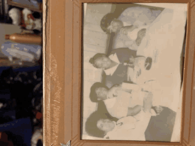 a group of people are sitting at a table in a picture frame
