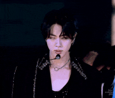 a man wearing a microphone and a necklace with a ring on it