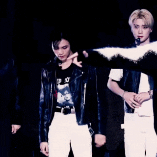 a blurry picture of a man and a woman singing into microphones