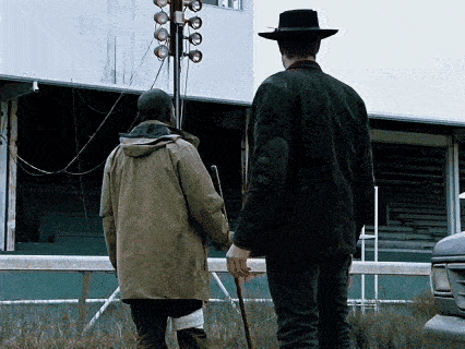 a man in a hat is walking with another man