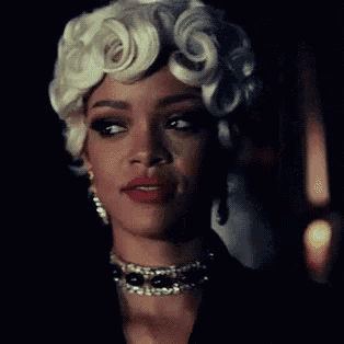 a woman wearing a choker and a wig is smiling in the dark .