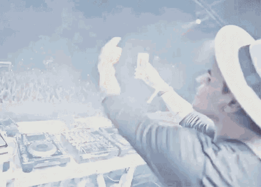 a man is taking a picture of himself in front of a crowd while playing music .