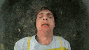 a man is laying in the grass with his eyes closed
