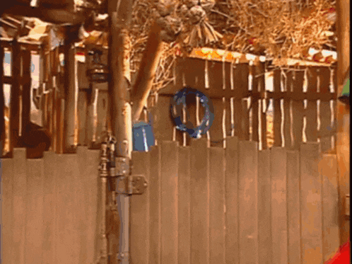 a wooden fence with a blue wreath hanging from it