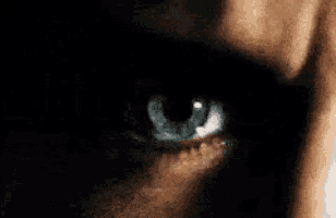 a close up of a man 's blue eye in the dark .