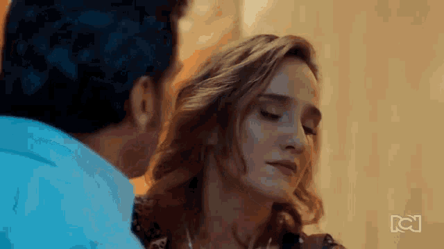 a man and a woman are looking into each other 's eyes in a room .