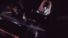 a man is holding a knife in a dark room .