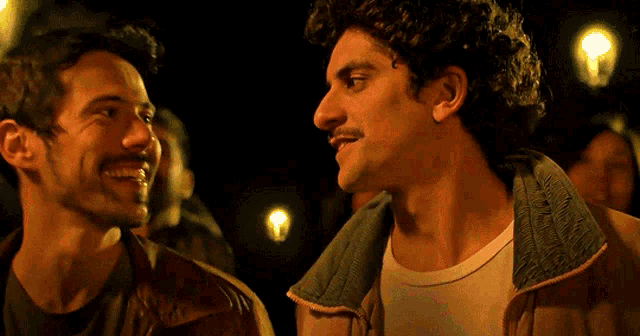 two men are smiling and looking at each other
