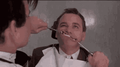 a man is getting his teeth examined by a dentist in a dental office .