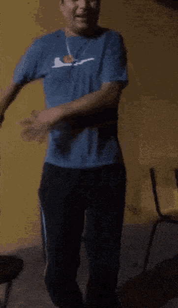 a man wearing a blue shirt with the letter a on it is dancing