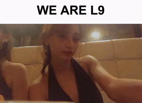 a woman is taking a selfie in front of a mirror with the words we are l9 above her .