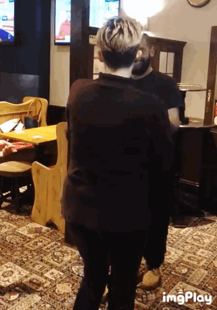 a couple of people standing in a room with the words imgplay visible
