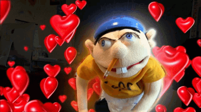 a puppet with a pencil in his mouth is surrounded by red hearts and says valentine 's day