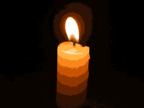 a candle is lit up in the dark with the flame visible