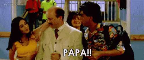 a group of people are standing next to each other in a room and one of them is saying papa !