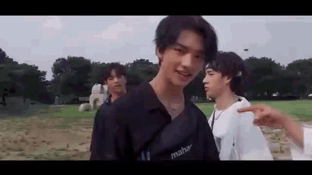 a group of young men are standing next to each other in a field .