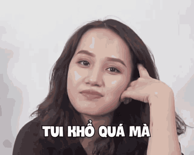 a woman with a hand on her chin and the words tui kho qua ma written below her