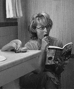 a woman reading a book called sex tips