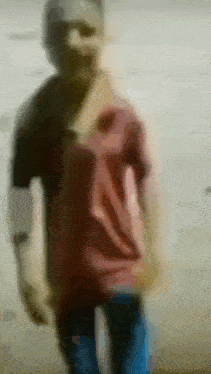 a blurry picture of a man in a red shirt and blue jeans