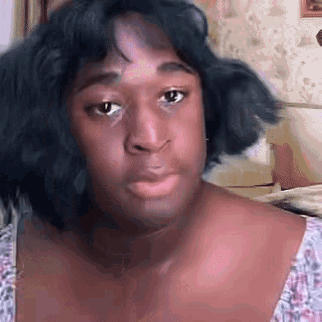 a woman with black hair and a pink shirt is making a funny face and looking at the camera .