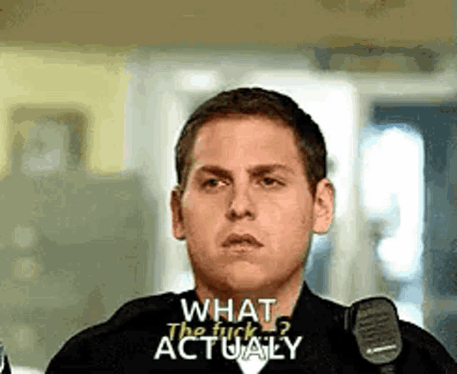 a police officer is talking into a microphone and asking what the fuck actually .