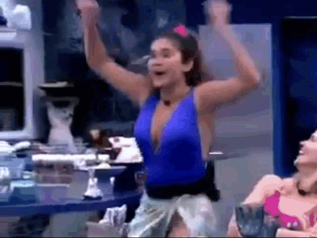 a woman in a blue swimsuit is dancing in a kitchen .