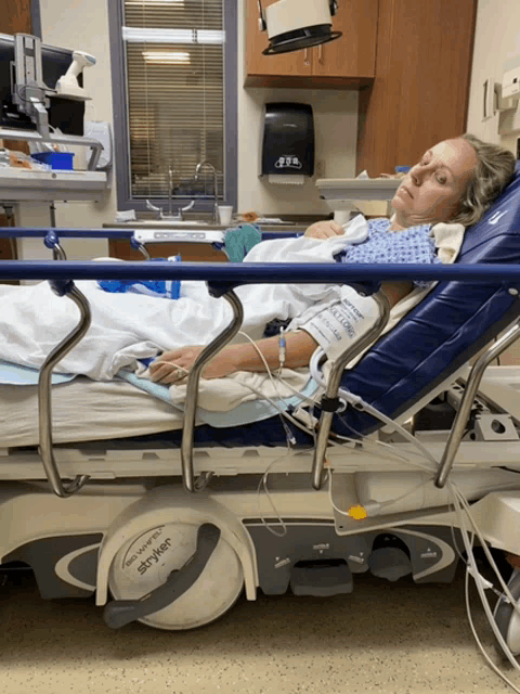 a woman is laying in a hospital bed with a device that says stryker on the side